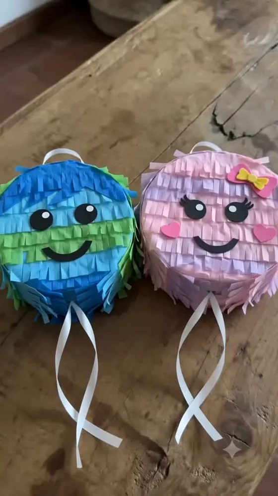 Dos piñatitas con caritas, una azul y verde y otra rosa